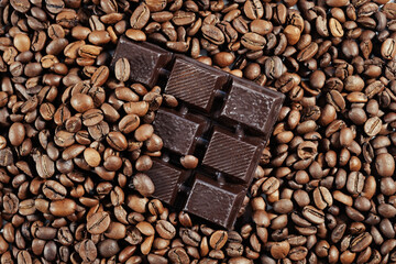 Coffee beans with broken chocolate slices close up. Chocolate coffee background. Top view