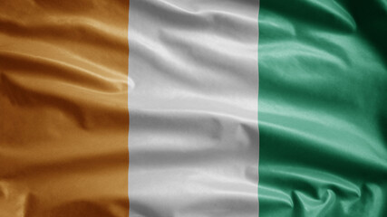 Ivoria flag waving in the wind. Close up of Ivory Coast banner blowing soft silk