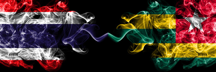 Thailand, Thai vs Togo smoky mystic flags placed side by side. Thick colored silky abstract smokes...