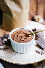 cocoa powder in a white bowl. cocoa ingredient for baking. cocoa powder and chocolate chunks for a pastry chef. ingredient for cake and brownie.