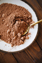 cocoa powder top view. cocoa powder on a white plate. slide of cocoa powder on a golden spoon. cocoa baking ingredient