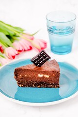 A slice of healthy chocolate brownie raw cake with hazelnuts, copy space