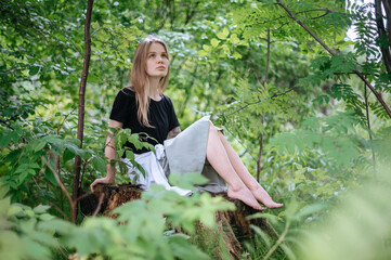Naklejka na ściany i meble Practice of meditation and interaction with nature. Girl in green forest