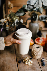 ecological thermo mug. reusable mug in female hands. bamboo glass. cup with place for brand