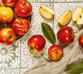 Plate with ripe multicolored apples on rustic tile.Top view.Still life.