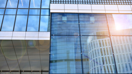Obraz premium Glass clad facade of a modern building covered in reflective plate glass.