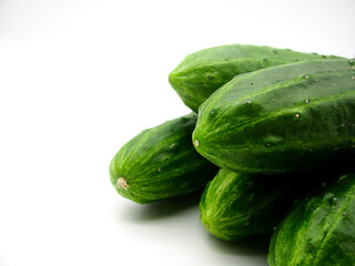 A group of fresh green cucumbers on a white background.