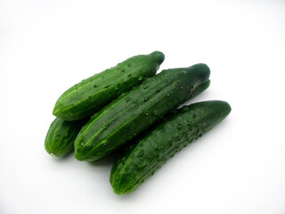 A group of fresh green cucumbers on a white background.