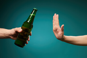 Female rejecting bottle beer showing stop gesture isolated over green background with copy space.Bad habit refusal, health care.