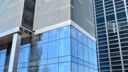 Glass clad facade of a modern building covered in reflective plate glass.