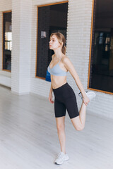 Fototapeta premium Girl doing stretching exercises in the gym. Sport, healthy lifestyle concept