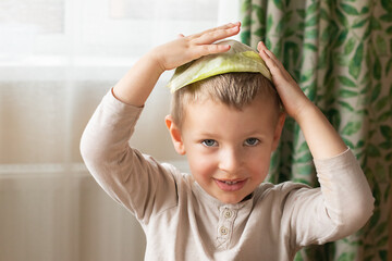 Blond boy with a cabbage leaf on his head