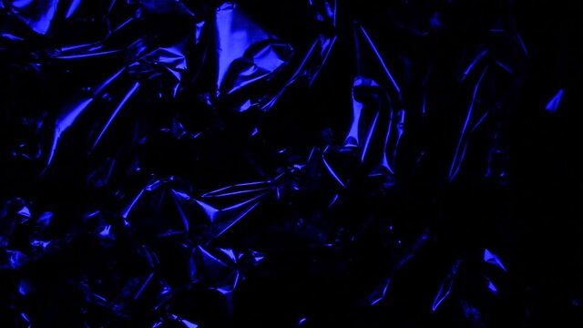 Glow. Foil background. Crumpled foil. Abstract background. Blue