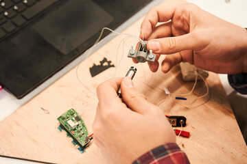 Male engineer sitting at the table and working with circuits and boards