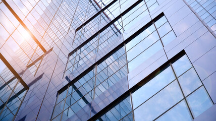 Obraz premium Glass clad facade of a modern building covered in reflective plate glass.