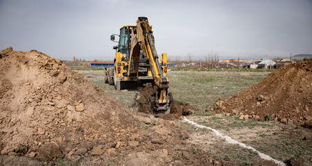 Backhoe bucket digging the soil