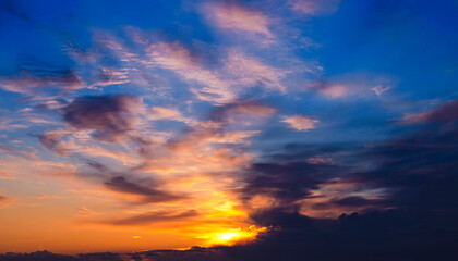 Fototapeta na wymiar A beautiful photo of a gorgeous spring sunset sky with clouds in shades of orange and blue. Beautiful background for your design, wallpaper, screensaver, site. Great for printing on poster
