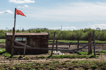Guard's booth with red flag and fields of beds in spring
