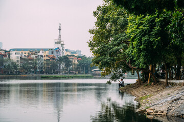 Fototapeta na wymiar Fisherman in downtown Hanoi, Vietnam