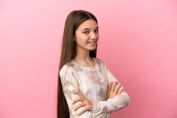 Obraz premium Little girl over isolated pink background with arms crossed and looking forward