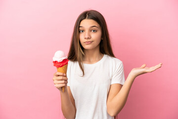 Little girl with a cornet ice cream over isolated pink background having doubts while raising hands