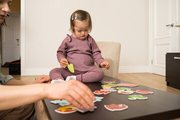 Concentrated down-syndrome girl playing at the educational game