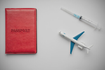 Passport, syringe and plane on the white background. Vaccination passport and traveling concept.