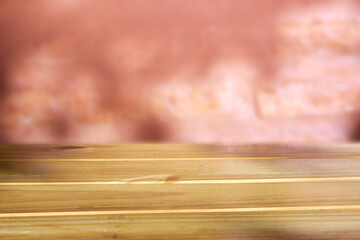 A rustic light brown wooden empty table top against red blurry brick wall background, can be used to display products.