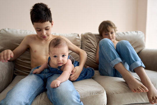 Family photo of three boys. Three brothers pose on the sofa. High quality photo