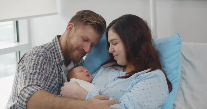 Happy mother and father with newborn baby at hospital