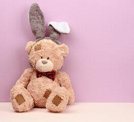 cute brown teddy bear wearing a rabbit mask with long ears on his head