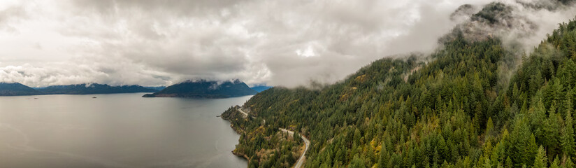 Aerial panoramic view of the Sea to Sky Highway in Howe Sound, North of Vancouver, British Columbia, Canada. Taken during a cloudy winter day.