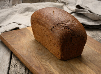 baked rectangular rye flour bread on brown board