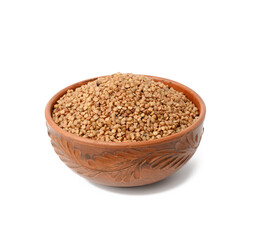 raw buckwheat grains in brown ceramic plate