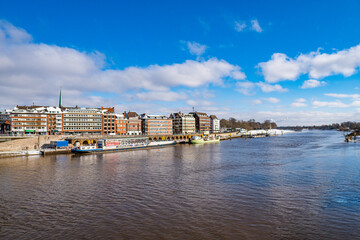 Obraz premium View from footbridge to river weser with some boats in the sunlight in bremen in winter