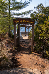 Fototapeta na wymiar A sign reading Path of Memories leads onto a dock overlooking a lake at the end of a short hiking trail in the small cottage town of Gravenhurst in the Muskoka region of Ontario.