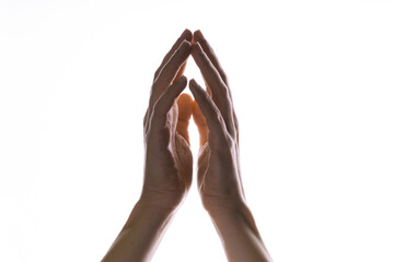 Praying hands on a white background. Light from above. Hands folded in prayer. Hand gestures