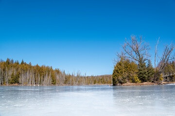 A lake is completely frozen in Mono Cliffs Provincial Park in Ontario on a beautiful sunny day.