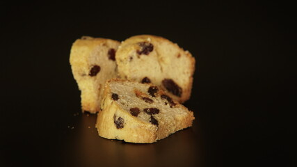 English cake pieces with the dry fruits on the black background. The three pieces of the muffin-type desserts that's are also called fruit cakes. The food art photography.                             