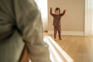 Girl with down syndrome going to her mother while playing at the sunny room