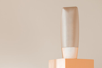 Foundation bottle mockup on podium pedestal, beige natural background. Liquid concealer packaging template mock up. Beauty cream cosmetics makeup product display