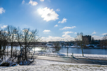 view from snowy rampart to dyke, weser and werdersee island at sunny warm winter day in bremen