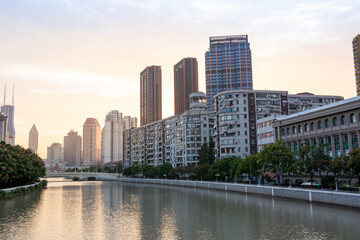 Shanghai, China - 11.01.2019: Downtown Shanghai Wuson River in golden sunset light, residential chinese modern buildings with green trees