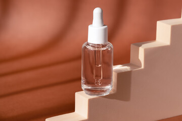 Glass cosmetic bottle mock up on staircase podium. Hyaluronic acid, serum skincare product on beige pedestal. Hyaluronic acid oil in dropper with peptide and collagen on brown background