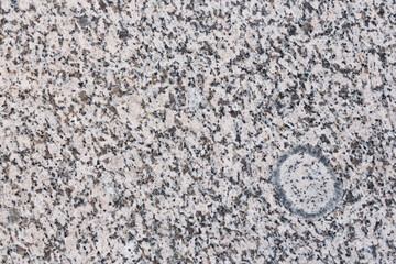Granite texture. Natural granite with a grainy pattern. Stone background. Solid rough surface of rock. Durable construction and decoration material. Close-up.