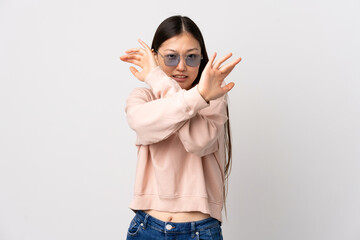 Young Chinese girl over isolated white background nervous stretching hands to the front