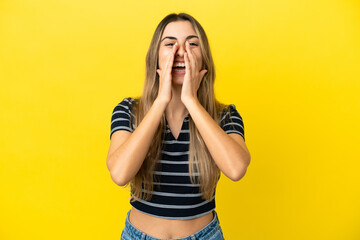 Young caucasian woman isolated on yellow background shouting and announcing something