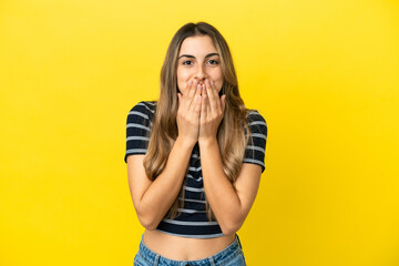 Young caucasian woman isolated on yellow background happy and smiling covering mouth with hands