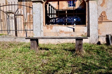 Old wooden bench in an abandoned place. An unusual bench in an ordinary place. An old wooden bench against the backdrop of a ruined abandoned building.