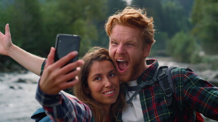 Man and woman taking selfie on phone. Friends making funny faces on camera